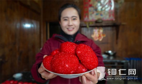 2022年1月14日，在贵州省铜仁市万山区敖寨乡杨家寨村，村民在展示刚出锅的红粑粑。