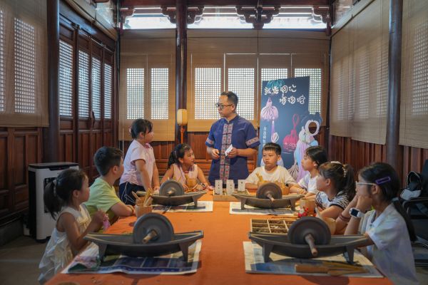 2025年7月25日，貴州省銅仁市碧江區(qū)銅仁博物館“梵凈藥香·苗韻傳承”中藥香包手工制作體驗活動現(xiàn)場，一名小朋友正在向工作人員提問。申逸愷 攝