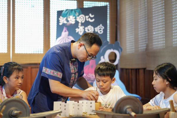 2025年7月25日，貴州省銅仁市碧江區(qū)銅仁博物館一名工作人員正幫助小朋友使用搗缽研磨用于制作中藥香包的原料。申逸愷 攝