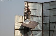 市城管局对全市楼顶广告进行整治拆除