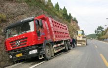 一辆大货车车轮掉进路边沟侧翻